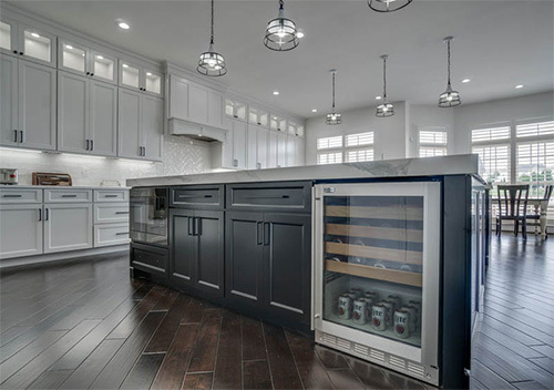 Kitchen island with black cabinets and built-in fridge done as part of our Woodlea Manor, Leesburg kitchen renovation.